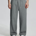 Model in dark grey Men's Fleece Sweatpants ¨C Wide Leg Heavyweight Lounge Pants with white sneakers, showing drape and relaxed fit.