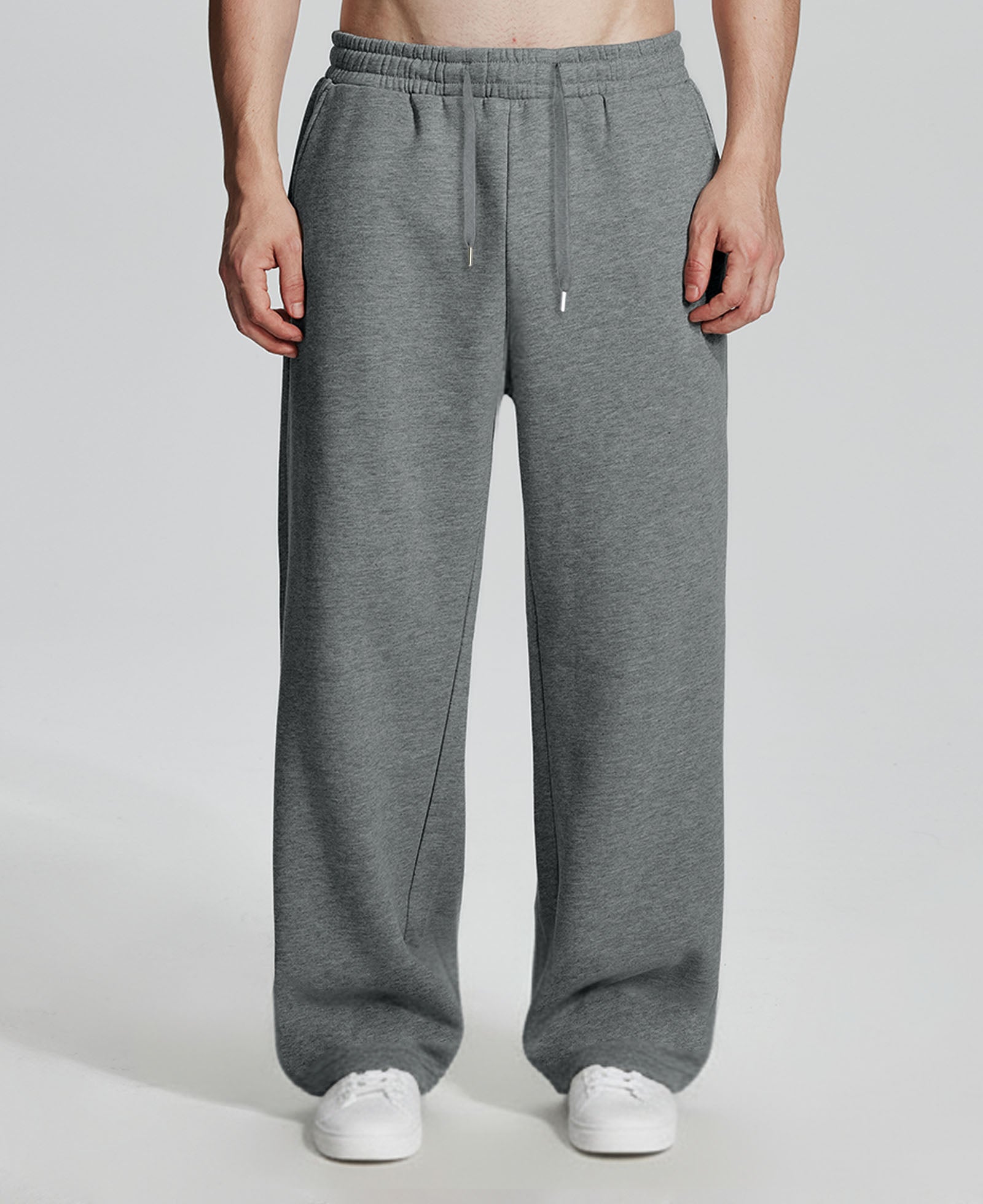 Model in dark grey Men's Fleece Sweatpants ¨C Wide Leg Heavyweight Lounge Pants with white sneakers, showing drape and relaxed fit.