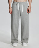 Model in light grey Men's Fleece Sweatpants ¨C Wide Leg Heavyweight Lounge Pants with white sneakers, showing drape and relaxed fit.
