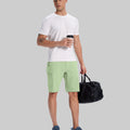 Model in white tee, light green Men's Golf & Hiking Shorts, and blue-gray sneakers with coffee cup¡ªshowing casual wear styling.