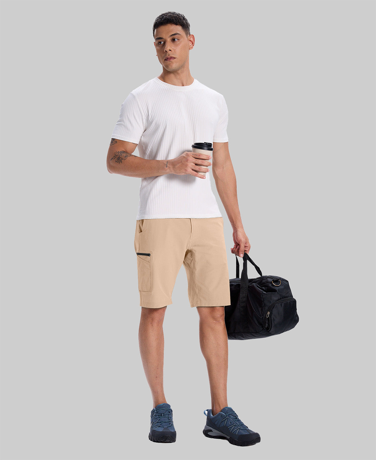 Model in white tee, khaki Men's Golf & Hiking Shorts, and blue-gray sneakers with coffee cup¡ªshowing casual wear styling.