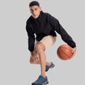 Model playing basketball in black jacket and khaki Men's Golf & Hiking Shorts¡ªdemonstrating versatility in sports settings.