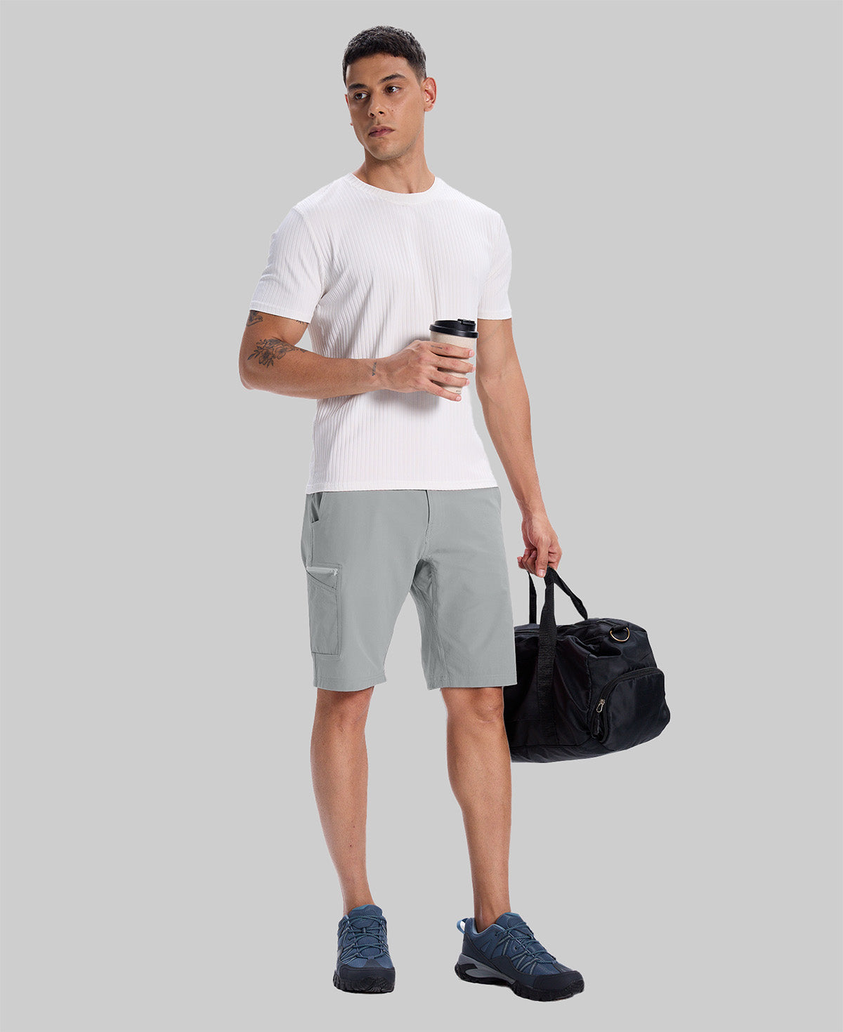 Model in white tee, light gray Men's Golf & Hiking Shorts, and blue-gray sneakers with coffee cup¡ªshowing casual wear styling.