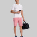 Model in white tee, pink Men's Golf & Hiking Shorts, and blue-gray sneakers with coffee cup¡ªshowing casual wear styling.