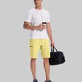 Model in white tee, light yellow Men's Golf & Hiking Shorts, and blue-gray sneakers with coffee cup¡ªshowing casual wear styling.