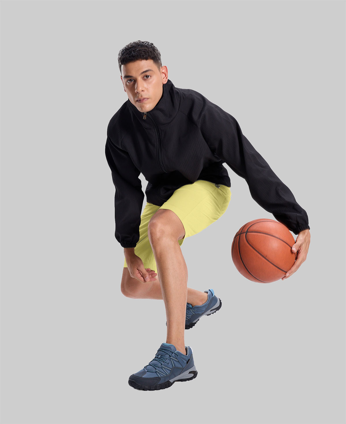 Model playing basketball in black jacket and light yellow Men's Golf & Hiking Shorts¡ªdemonstrating versatility in sports settings.