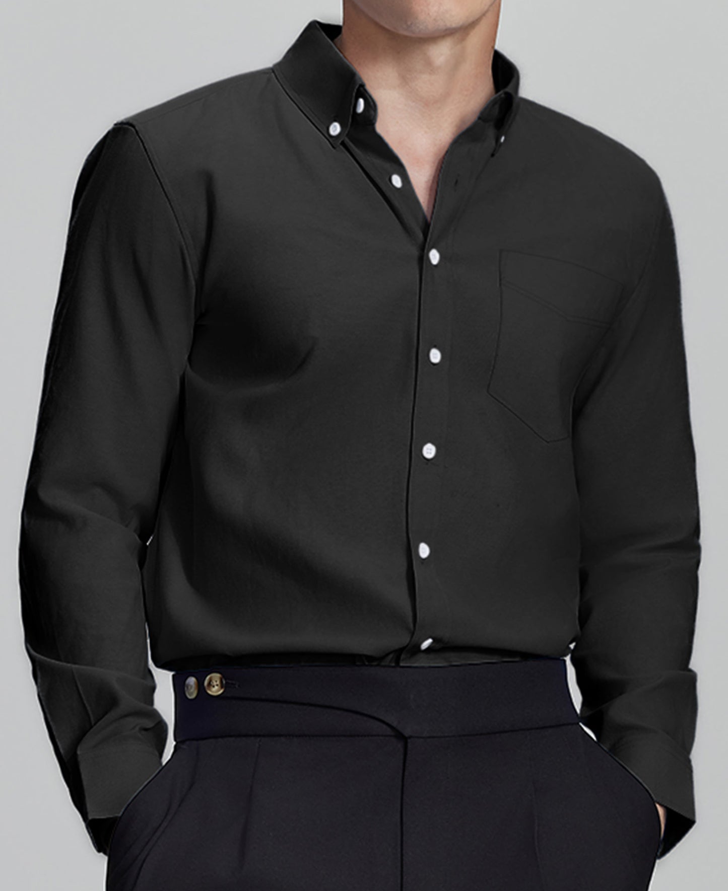 Man in black Men's Oxford Button Down Dress Shirt ¨C Wrinkle Resistant, with matching trousers and hand in pocket.