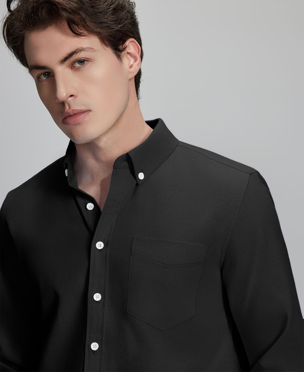 Close-up of placket, chest pocket, and buttons on wrinkle-resistant Oxford shirt, showing textured fabric quality.