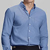 Man in deep blue Men's Oxford Button Down Dress Shirt ¨C Wrinkle Resistant, with matching trousers and hand in pocket.