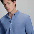 Close-up of placket, chest pocket, and buttons on wrinkle-resistant Oxford shirt, showing textured fabric quality.