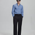 Full outfit: deep blue Oxford shirt, wide-leg dress pants & brown shoes, minimalist yet polished style.