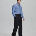 Side profile of model in deep blue Oxford shirt and trousers, clean lines and sharp silhouette.