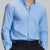 Man in light blue Men's Oxford Button Down Dress Shirt ¨C Wrinkle Resistant, with matching trousers and hand in pocket.