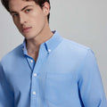 Close-up of placket, chest pocket, and buttons on wrinkle-resistant Oxford shirt, showing textured fabric quality.