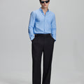 Full outfit: light blue Oxford shirt, wide-leg dress pants & brown shoes, minimalist yet polished style.