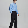 Side profile of model in light blue Oxford shirt and trousers, clean lines and sharp silhouette.