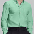 Man in light green Men's Oxford Button Down Dress Shirt ¨C Wrinkle Resistant, with matching trousers and hand in pocket.