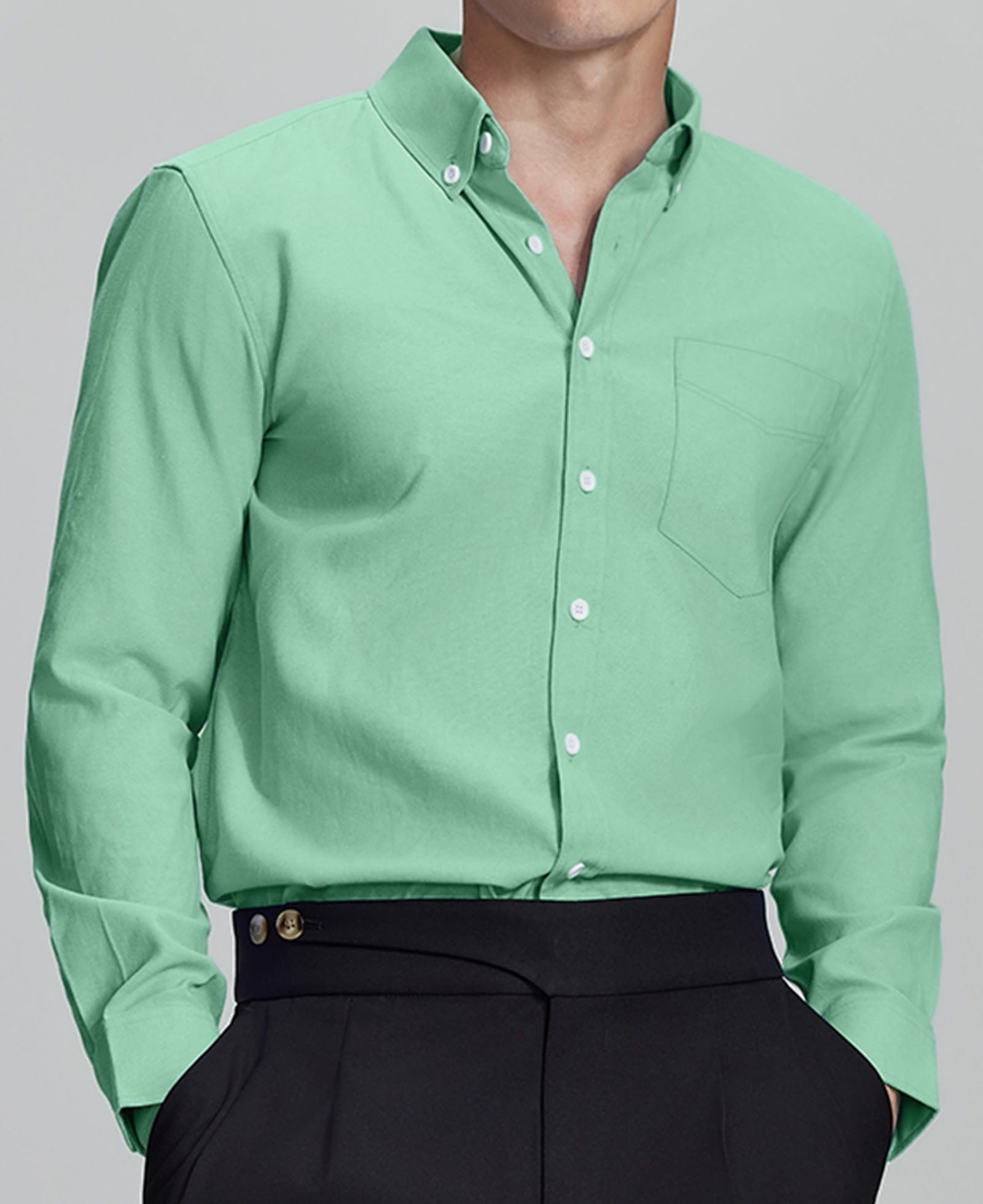 Man in light green Men's Oxford Button Down Dress Shirt ¨C Wrinkle Resistant, with matching trousers and hand in pocket.