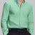 Man in light green Men's Oxford Button Down Dress Shirt ¨C Wrinkle Resistant, with matching trousers and hand in pocket.