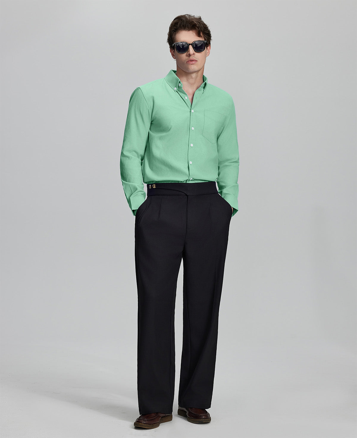 Full outfit: light green Oxford shirt, wide-leg dress pants & brown shoes, minimalist yet polished style.