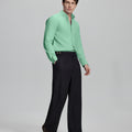 Side profile of model in light green Oxford shirt and trousers, clean lines and sharp silhouette.