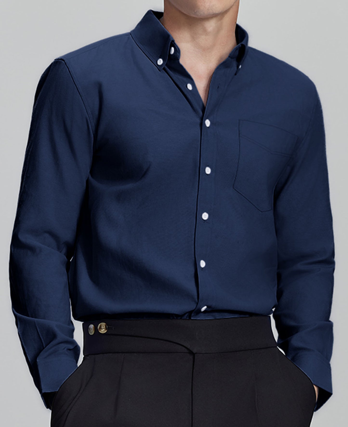 Man in navy blue Men's Oxford Button Down Dress Shirt ¨C Wrinkle Resistant, with matching trousers and hand in pocket.