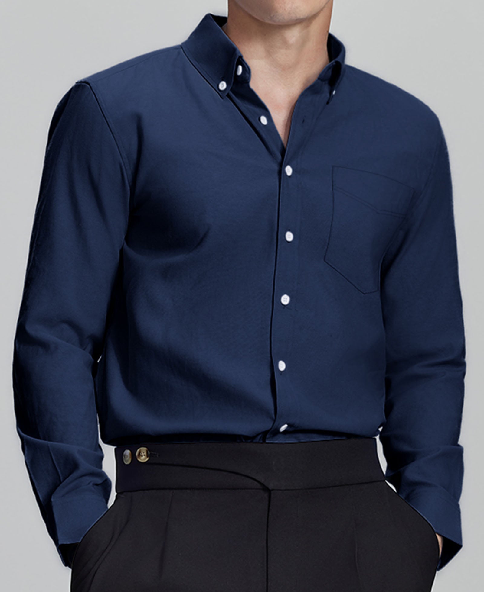 Man in navy blue Men's Oxford Button Down Dress Shirt ¨C Wrinkle Resistant, with matching trousers and hand in pocket.