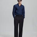 Full outfit: navy blue Oxford shirt, wide-leg dress pants & brown shoes, minimalist yet polished style.