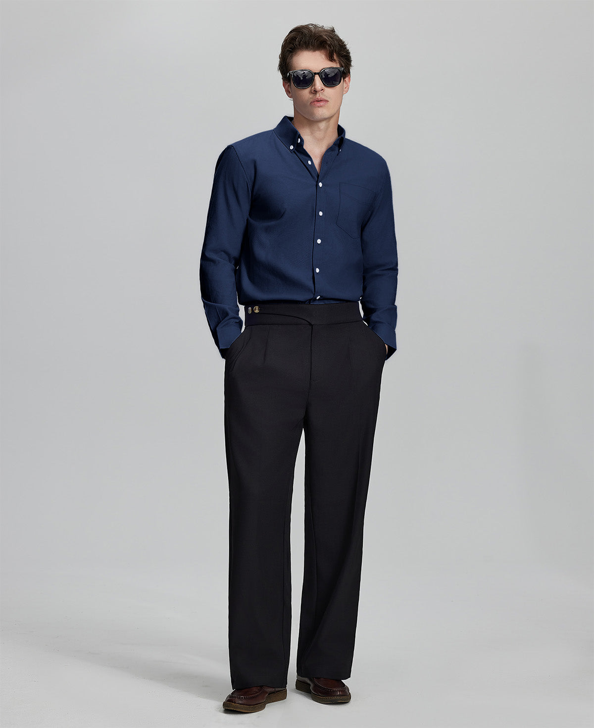 Full outfit: navy blue Oxford shirt, wide-leg dress pants & brown shoes, minimalist yet polished style.