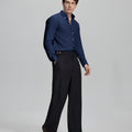 Side profile of model in navy blue Oxford shirt and trousers, clean lines and sharp silhouette.