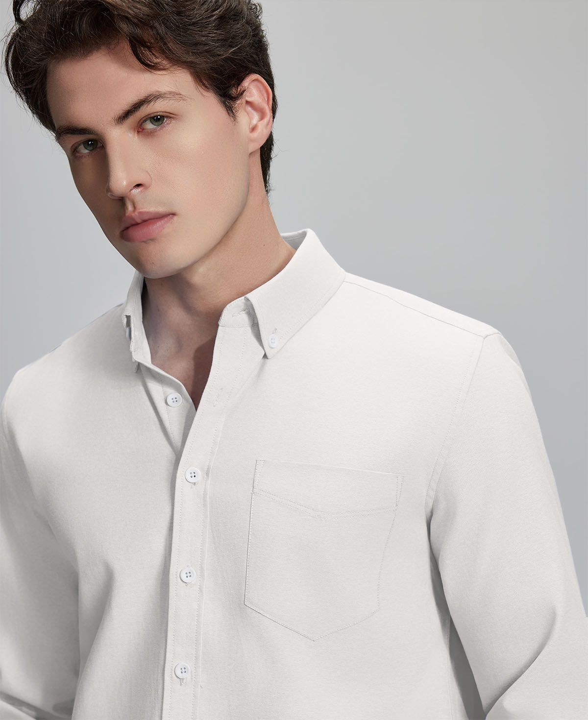 Close-up of placket, chest pocket, and buttons on wrinkle-resistant Oxford shirt, showing textured fabric quality.