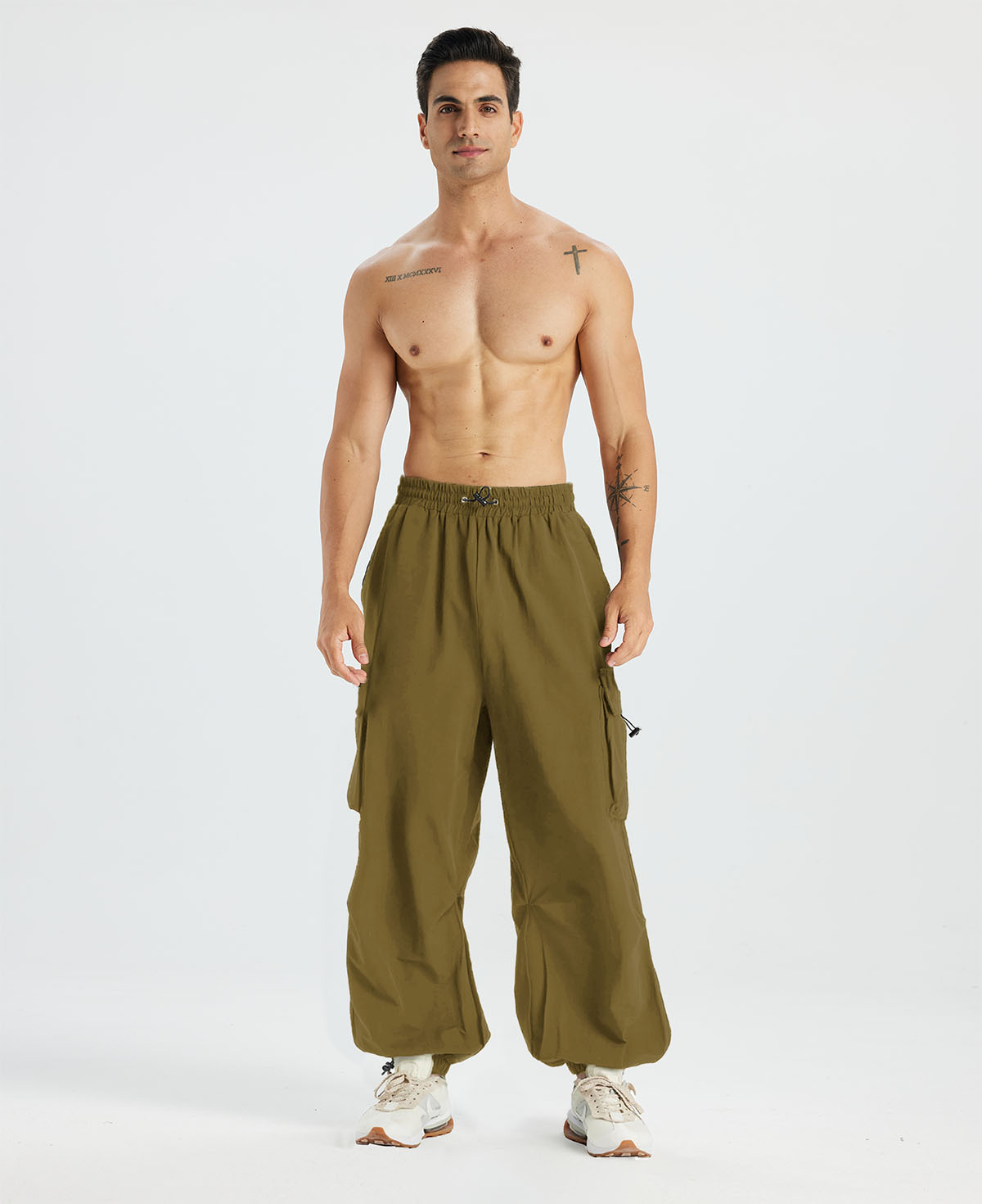 Bare-chested man in brown baggy sweatpants, white shoes, highlighting waist and length details.