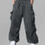Man in dark grey baggy sweatpants, high waist, five pockets, back logo. White sneakers, standing front.