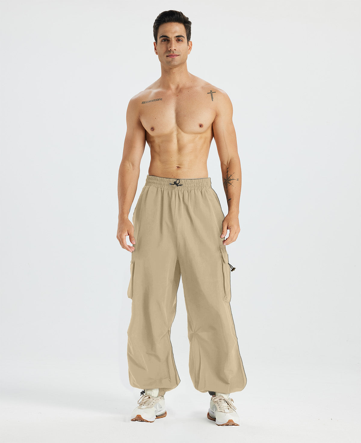 Bare-chested man in khaki baggy sweatpants, white shoes, highlighting waist and length details.