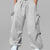 Man in light grey baggy sweatpants, high waist, five pockets, back logo. White sneakers, standing front.