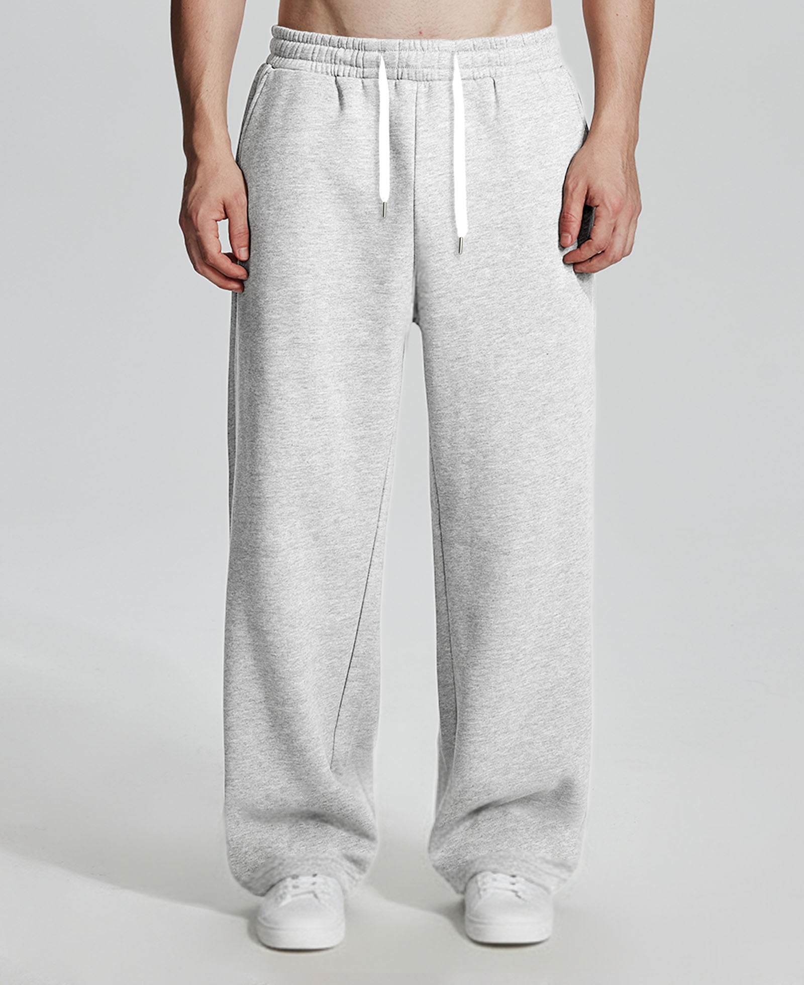 Model in white Men's Fleece Sweatpants ¨C Wide Leg Heavyweight Lounge Pants with white sneakers, showing drape and relaxed fit.