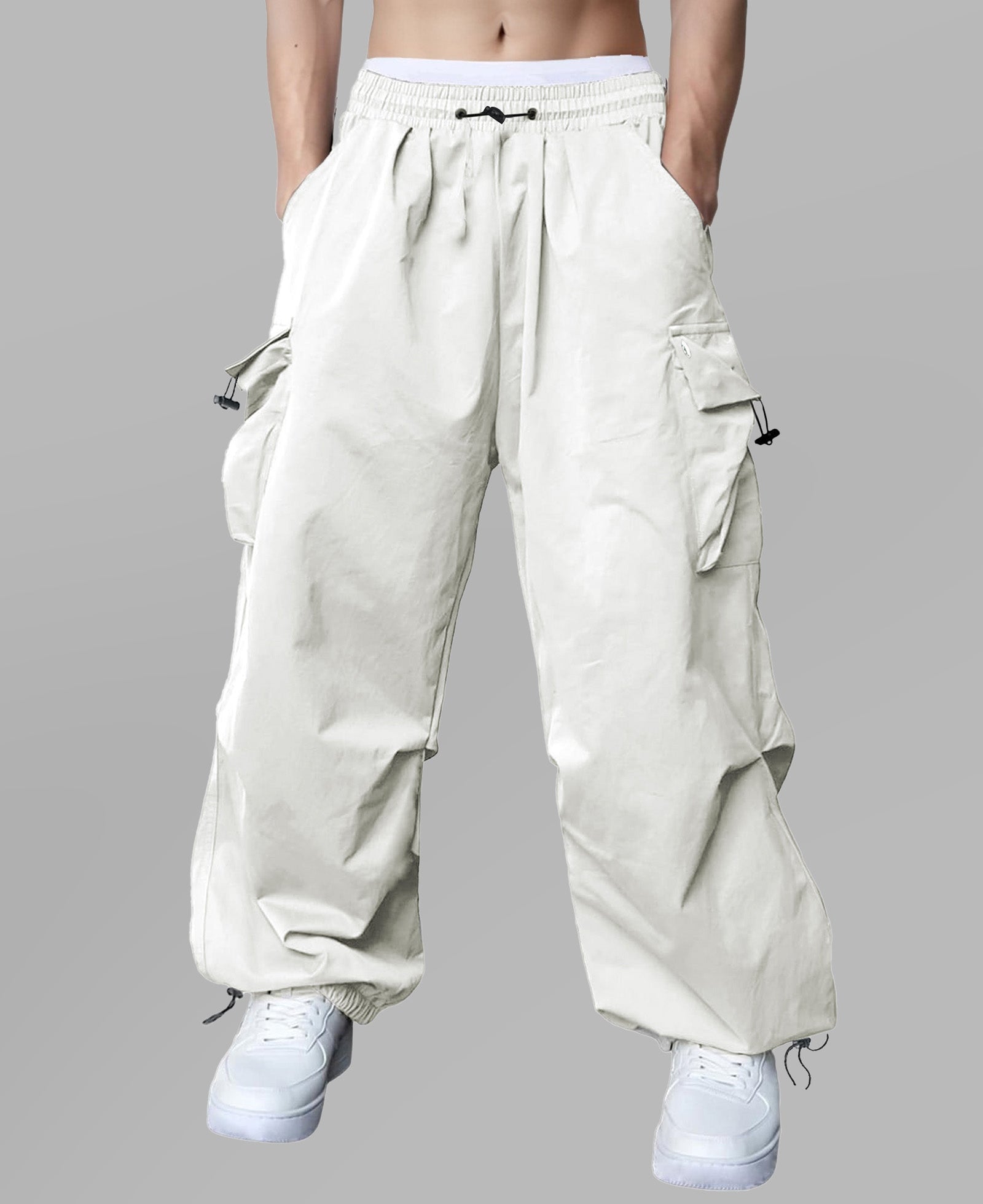 Man in white baggy sweatpants, high waist, five pockets, back logo. White sneakers, standing front.