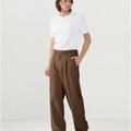 Model in white tee paired with brown Men's Pleated Baggy Dress Pants showing fresh casual style.