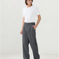 Model in white tee paired with dark grey Men's Pleated Baggy Dress Pants showing fresh casual style.