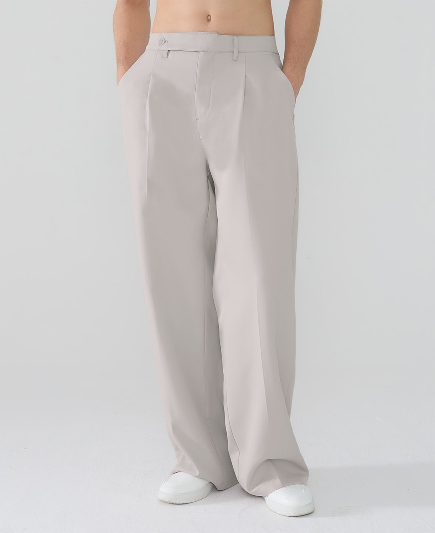 Model showcasing light gray Men's Pleated Baggy Dress Pants highlighting soft color and elegant drape.