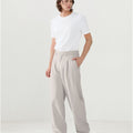 Model in white tee paired with light gray Men's Pleated Baggy Dress Pants showing fresh casual style.