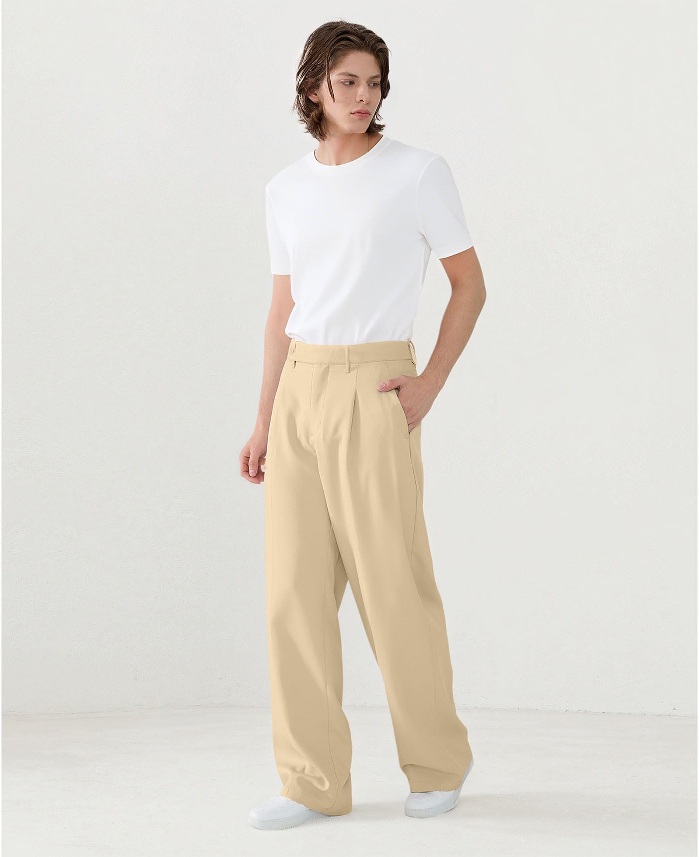 Model in white tee paired with light khaki Men's Pleated Baggy Dress Pants showing fresh casual style.