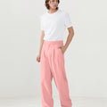 Model in white tee paired with pink Men's Pleated Baggy Dress Pants showing fresh casual style.