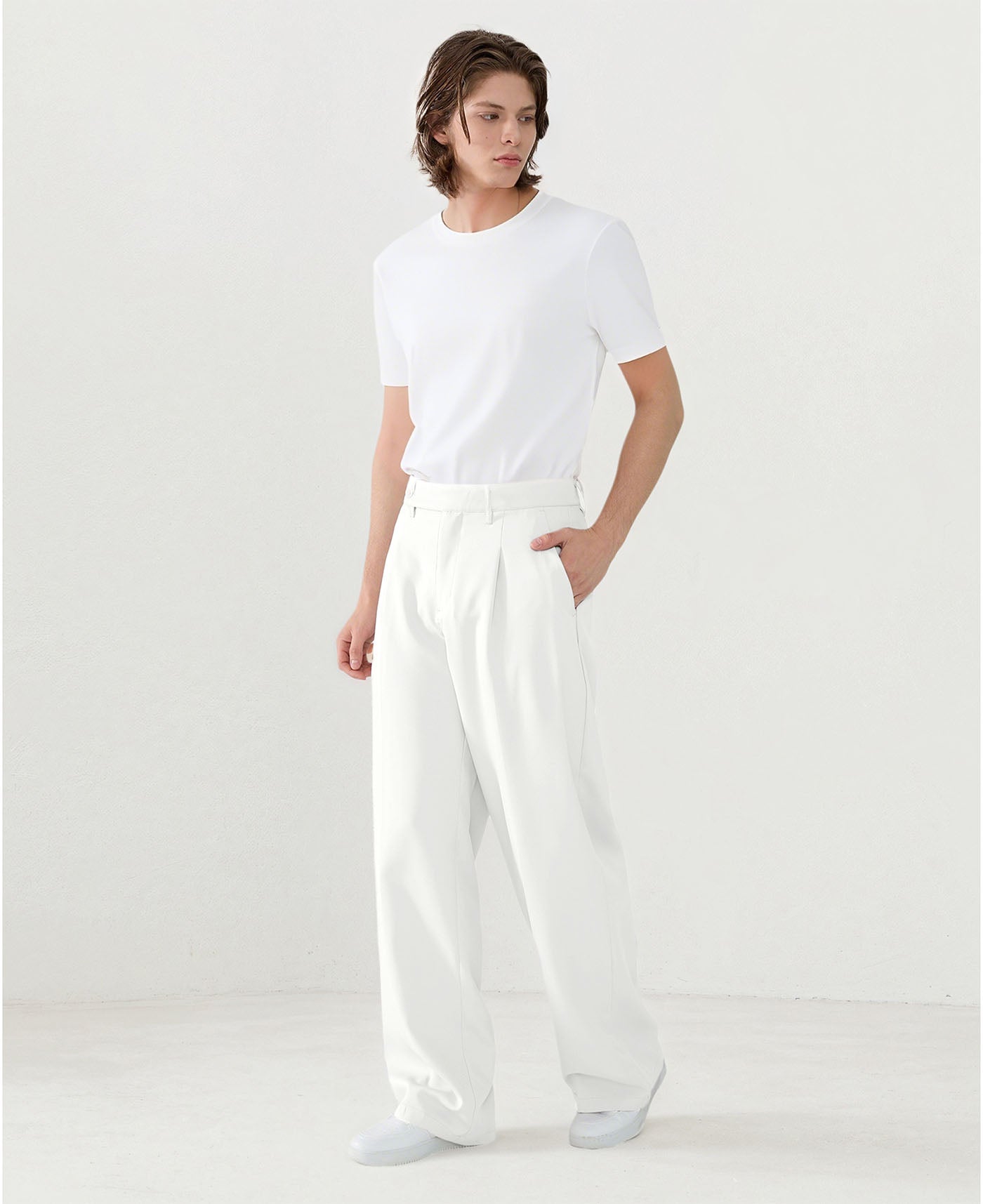 Model in white tee paired with white Men's Pleated Baggy Dress Pants showing fresh casual style.
