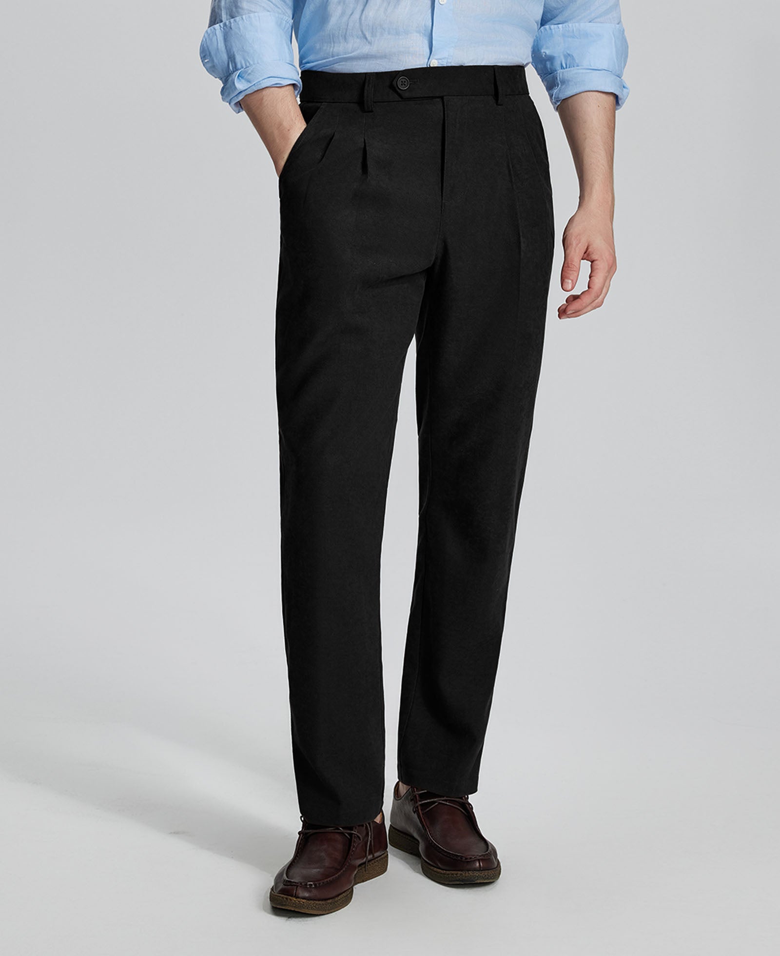 Man in light blue shirt, black Mens Pleated Dress Pants, and brown shoes showcasing regular fit & straight-leg style.