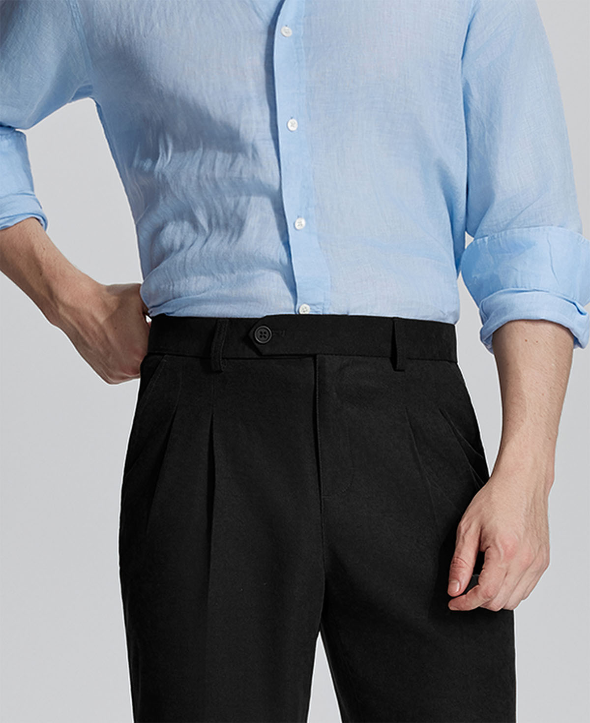 Close-up of waistband on Mens Pleated Dress Pants, highlighting button closure and tailored pleats for a refined look.