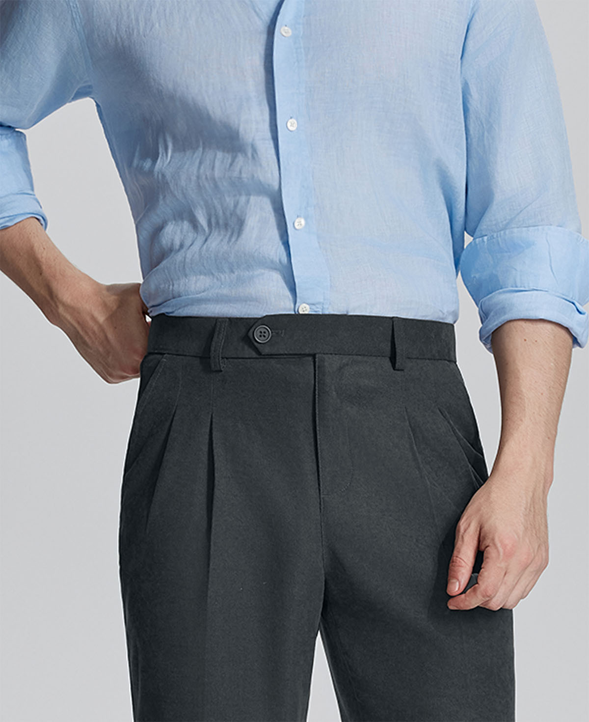 Close-up of waistband on Mens Pleated Dress Pants, highlighting button closure and tailored pleats for a refined look.
