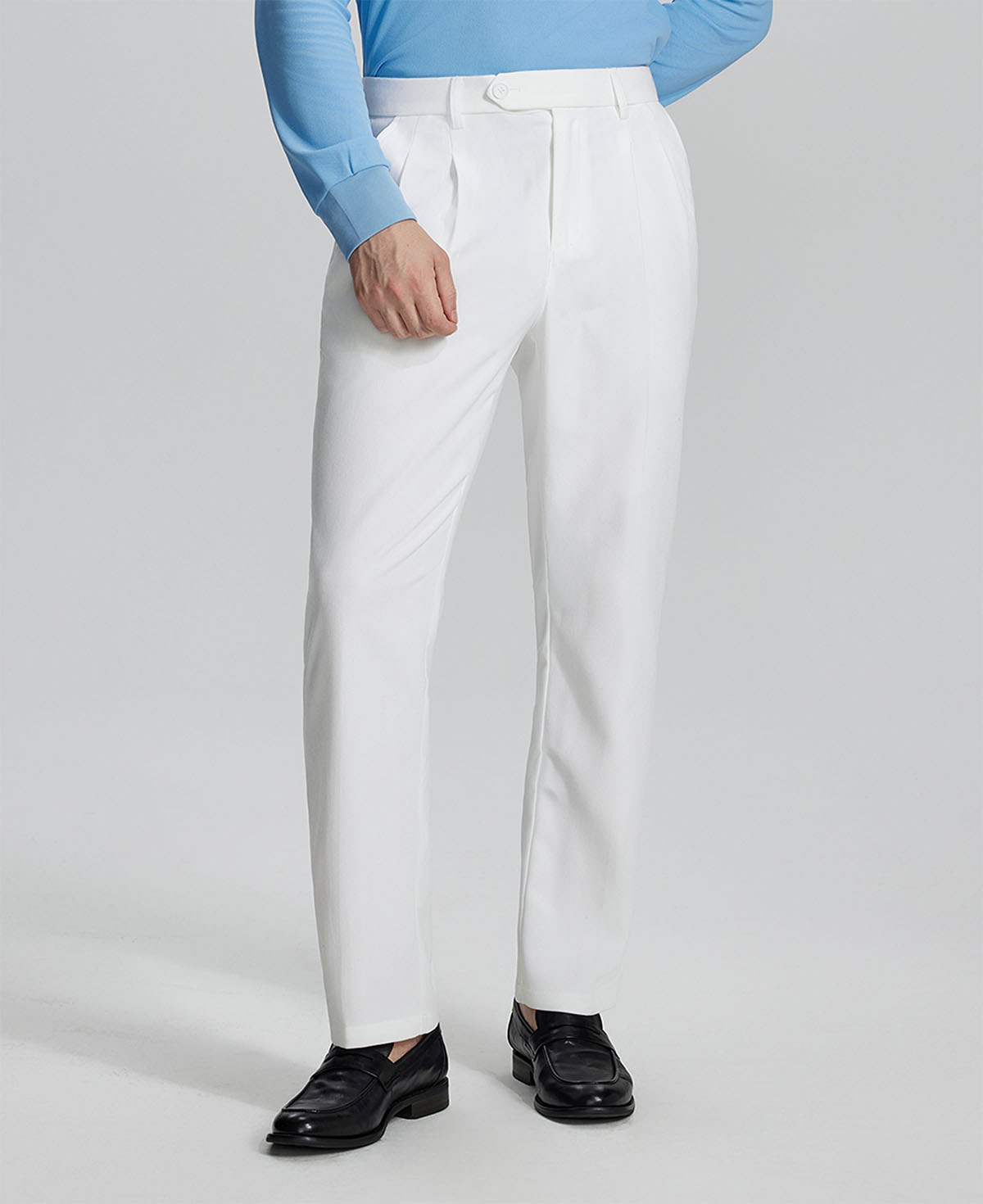 Man in light blue shirt, white Mens Pleated Dress Pants, and brown shoes showcasing regular fit & straight-leg style.