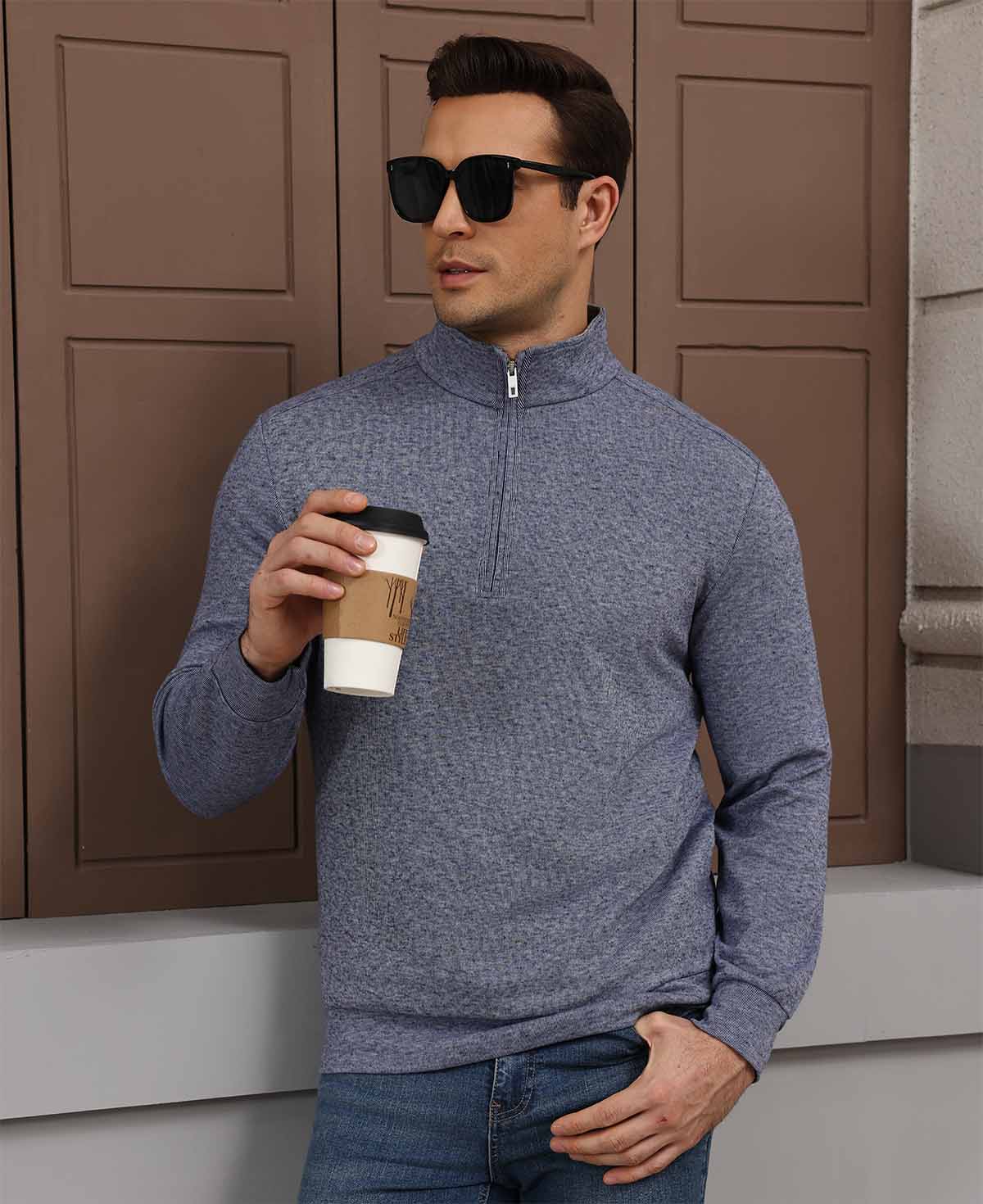 Model holding coffee in navy blue Men's Quarter Zip Sweater, comfortable look for light casual settings.