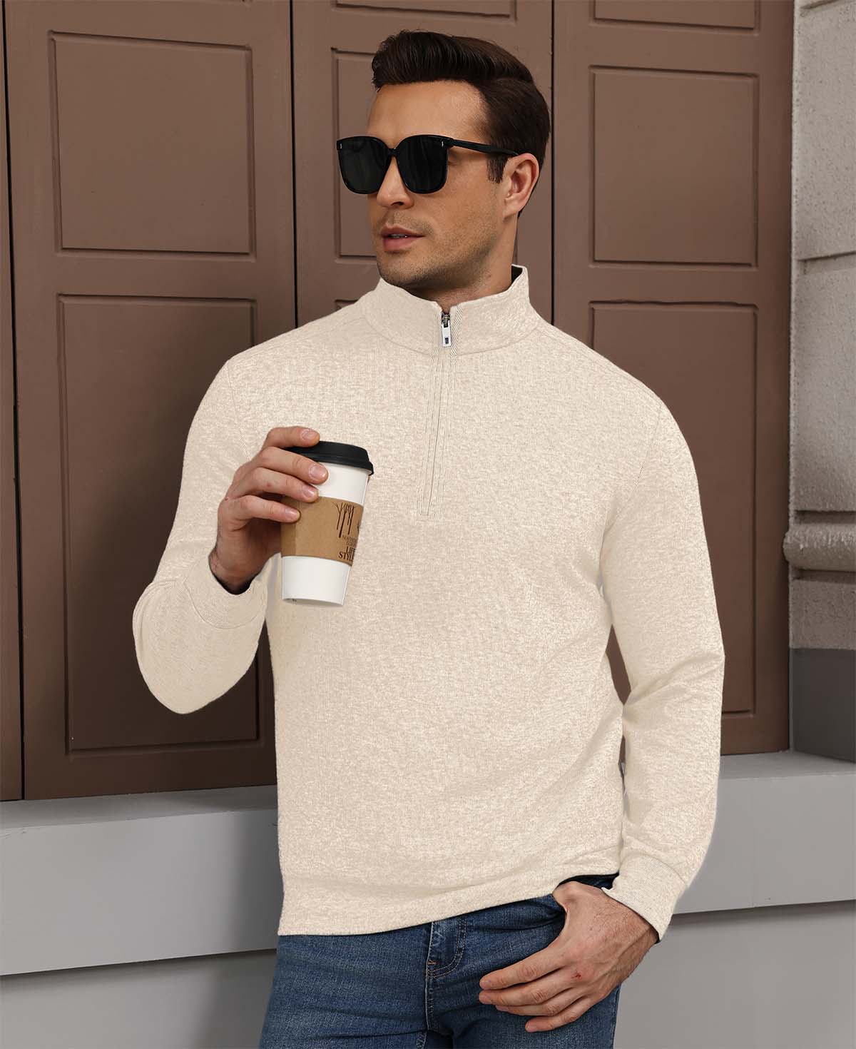 Model holding coffee in white Men's Quarter Zip Sweater, comfortable look for light casual settings.